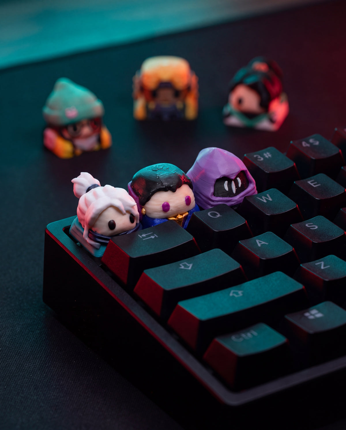 Tres keycaps de agentes de Valorant montadas en un teclado mecánico negro