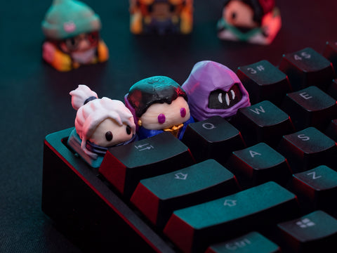 Tres keycaps de agentes de Valorant montadas en un teclado mecánico negro